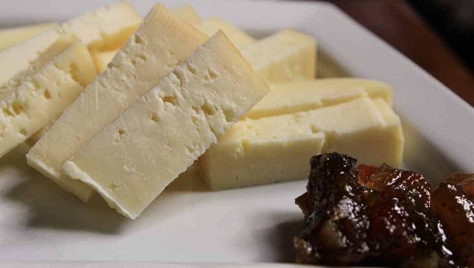 Young cheese is cut into slices and served to the table